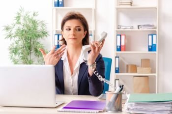 Middle-aged female employee sitting at the office  