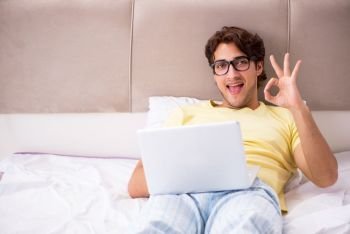 Student with laptop lying on the bed 