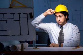 Young construction architect working on project at night 
