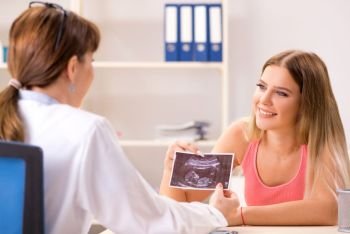 Beautiful pregnant woman visiting female gynecologist  