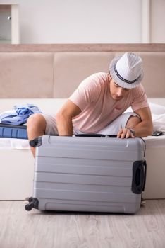 Man with suitcase in bedroom waiting for trip 