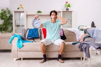 Young man husband ironing at home 