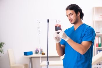 Young male doctor in blood transfusion concept 