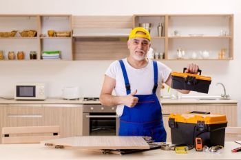 Aged contractor repairman working in the kitchen 