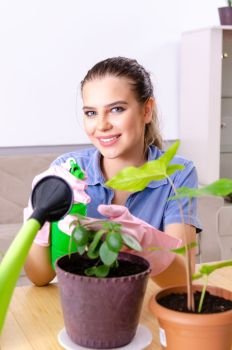 Young female gardener with plants indoors 