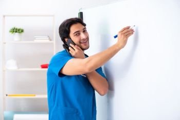Young male doctor in front of whiteboard 