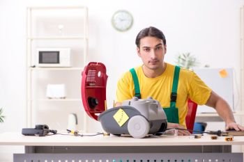 Man repairman repairing vacuum cleaner 