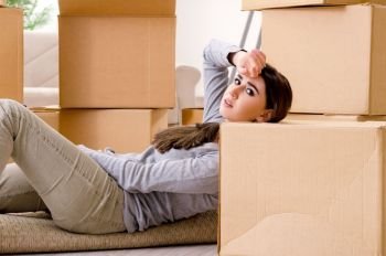 Young beautiful woman moving to new flat 