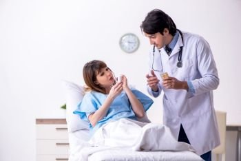 Male doctor visiting female patient in ward 