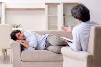 Young male patient discussing with psychologist personal problems . Young male patient discussing with psychologist personal problem