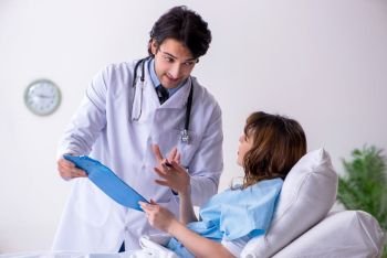 Male doctor visiting female patient in ward 