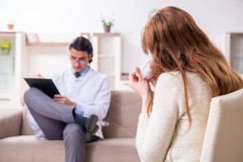 The young female patient discussing with male psychologist personal . Young female patient discussing with male psychologist personal 
