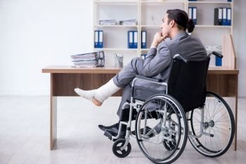 Male employee in wheel-chair in the office 