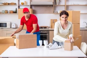 Young male contractor and female customer in moving concept  