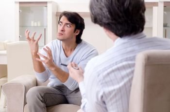 Young male patient discussing with psychologist personal problems . Young male patient discussing with psychologist personal problem