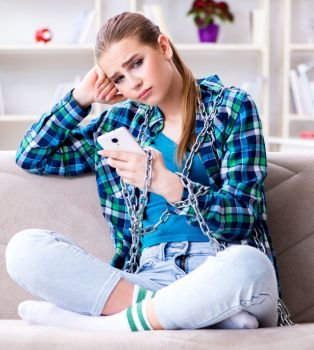The chained female student with mobile sitting on the sofa. Chained female student with mobile sitting on the sofa
