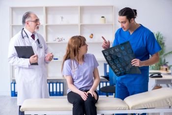 The two doctors examining young woman . Two doctors examining young woman 