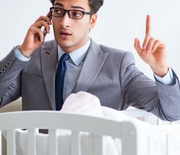 Young businessman trying to work from home caring after newborn baby. Young businessman trying to work from home caring after newborn 