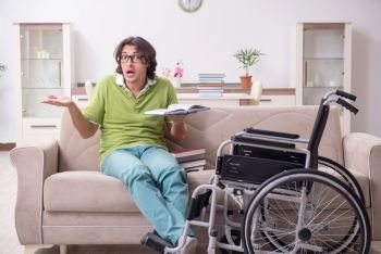 Young male student in wheelchair at home