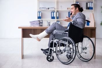 The male employee in wheel-chair in the office . Male employee in wheel-chair in the office 