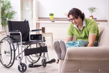 The young male invalid in wheelchair suffering at home. Young male invalid in wheelchair suffering at home