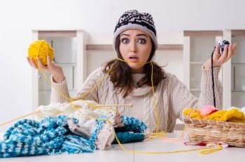 The young beautiful woman knitting at home . Young beautiful woman knitting at home 