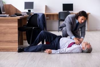 The male employee suffering from heart attack in the office. Male employee suffering from heart attack in the office