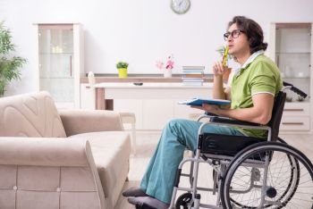 The young male student in wheelchair at home. Young male student in wheelchair at home