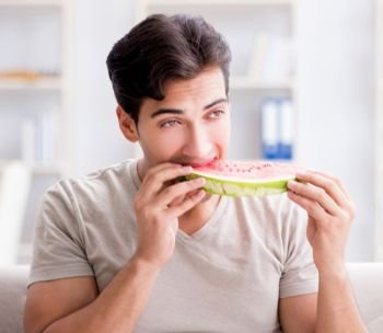 The man eating watermelon at home. Man eating watermelon at home