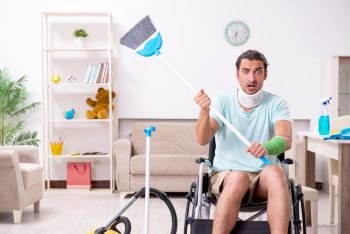 The young man in wheel-chair cleaning the house. Young man in wheel-chair cleaning the house