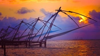 Panorama of Kochi tourist attraction - chinese fishnets on sunset with grunge texture overlaid. Fort Kochin, Kochi, Kerala, India. Chinese fishnets on sunset. Kochi, Kerala, India