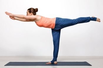 Beautiful sporty fit woman practices yoga asana Virabhadrasana 3 - warrior 3 pose. Woman practices yoga asana utthita Virabhadrasana
