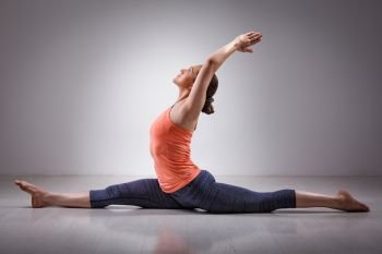 Sporty fit woman doing Hatha yoga asana Hanumanasana  (splits) - monkey pose. Sporty fit woman doing yoga asana Hanumanasana 