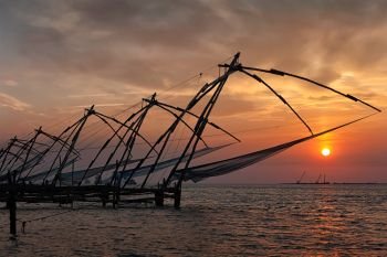 Kochi tourist attraction - chinese fishnets on sunset. Fort Kochin, Kochi, Kerala, India. Chinese fishnets on sunset. Kochi, Kerala, India