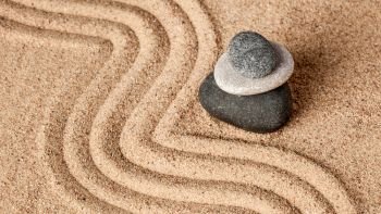 Japanese Zen stone garden - relaxation, meditation, simplicity and balance concept  - panorama of pebbles and raked sand tranquil calm scene. Japanese Zen stone garden