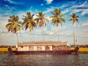 Kerala India tourism travel concept background - vintage retro effect filtered hipster style image of Houseboat on Kerala backwaters. Kerala, India. Houseboat on Kerala backwaters, India