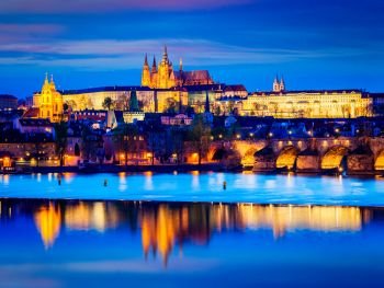 Travel Prague Europe tourism concept background - view of Charles Bridge and Prague Castle in twilight. Prague, Czech Republic. View of Charles Bridge and Prague Castle in twilight