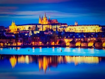 Travel Prague Europe tourism concept background - vintage retro effect filtered hipster style image of view of Charles Bridge and Prague Castle in twilight. Prague, Czech Republic. View of Charles Bridge and Prague Castle in twilight
