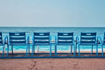 Famous blue chairs bench on beach in the morning. Nice, France. Famous blue chairs on beach of Nice, France