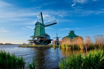 Netherlands rural lanscape Windmills at famous tourist site Zaanse Schans in Holland. Zaandam, Netherlands. Windmills at Zaanse Schans in Holland on sunset. Zaandam, Netherlands