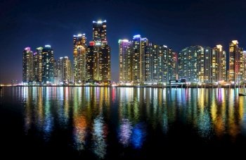 Panorama of Busan Marina city skyscrapers illluminated in night with reflection in water, South Korea. Busan Marina city skyscrapers illluminated in night