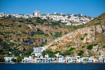 Klima and Plaka villages with whitewhashed traditional houses and orthodox church and windmills on Milos island, Greece. Klima and Plaka villages on Milos island, Greece