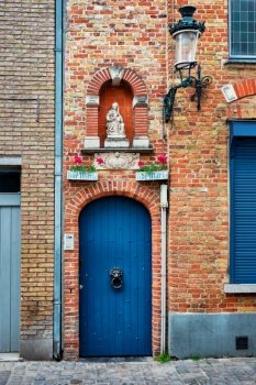 Door and window of an old house with Virgin Mary statue, Bruges (Brugge), Belgium. House in Bruges Brugge , Belgium