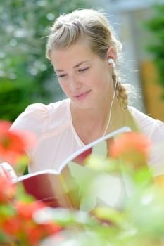 woman reading book with headset