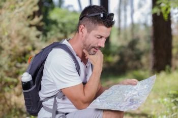 hiker with map exploring wilderness on trekking adventure