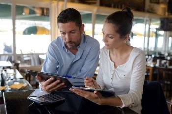 handsome couple in a bar using a digital tablet