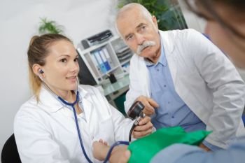 doctor and nurse measuring blood pressure of a patient