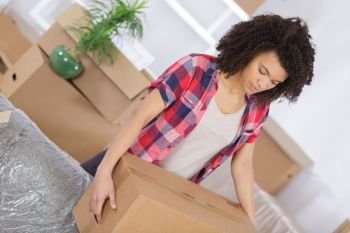 young girl arranging interior and unpacking at new apartment