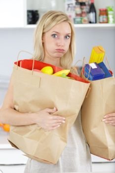 young woman carrying heavy shopping bags