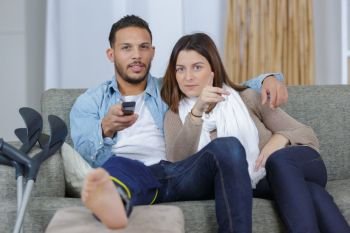 young couple watching tv on a sofa at home